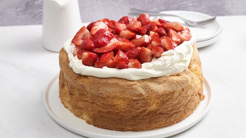 Completed sponge cake topped with whipped double cream and strawberries